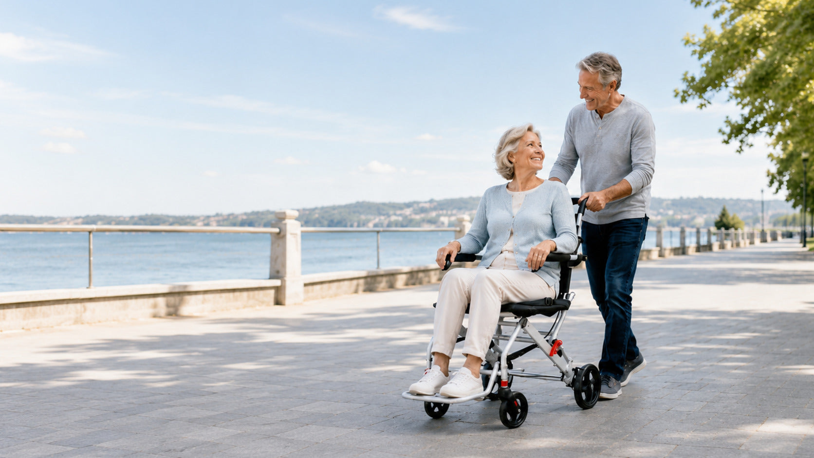 Older couple enjoying a relaxed waterfront outing with a compact folding wheelchair